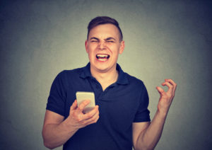 Frustrated man viewing emails on a SmartPhone